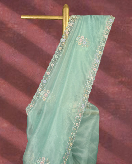 Aqua Green colour pure organza saree featuring all over floral sequin work, adorned with a matching intricately worked floral border, complemented by a richly embellished pallu and paired with a heavily worked matching blouse.