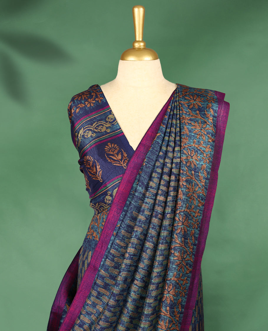 Blue Colour Manipuri saree features a brick patterned body in olive and indigo hues, beautifully offset by a contrasting magenta border with copper floral-printed, and comes with a matching blouse.