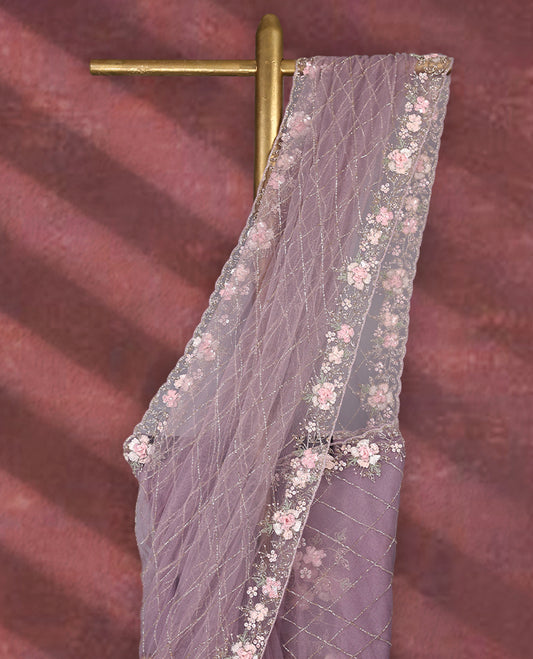 Lavender colour net designer saree featuring crisscross cut beads detailing on the body, adorned with beads and sequin worked floral kodi scallop border, paired with a matching worked blouse