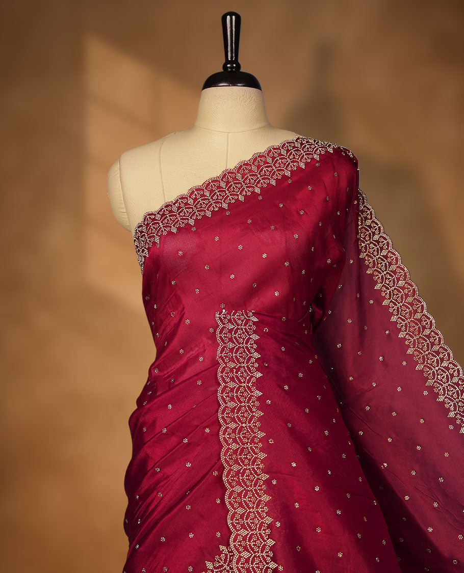 Dark Magenta Colour net shimmer fancy saree adorned with scattered white stone buttas all over the body, paired with a delicate stone worked border and matching blouse featuring floral vine stone embroidery