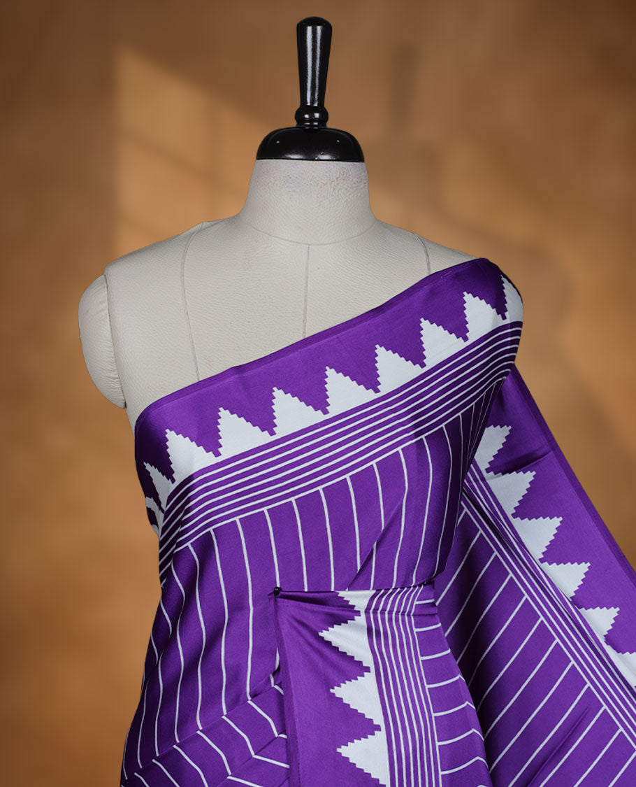 Violet colour semi modal saree featuring white colour geometric borders and fine stripe detailing, finished with an oversized circular motif on the pallu, paired with a matching printed blouse.