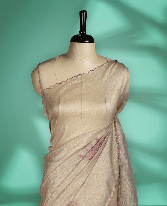 Beige gold colour organza designer saree featuring a subtle shimmer woven body with delicate green floral Soft mauve embroidery, scalloped thread detailing along the border and pallu paired with matching blouse.