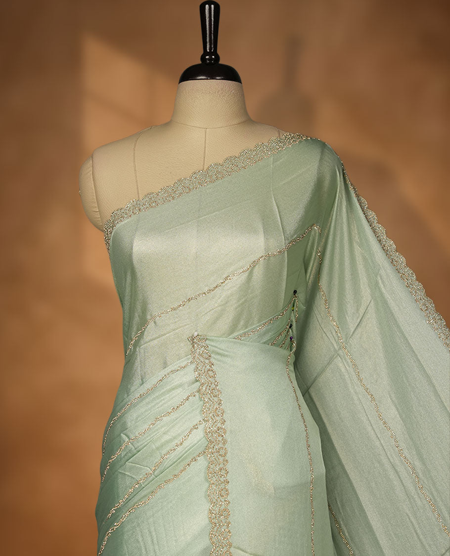 Pastel Green colour net shimmer fancy saree adorned with white stone buttas, paired with a delicate stone worked border and matching blouse.