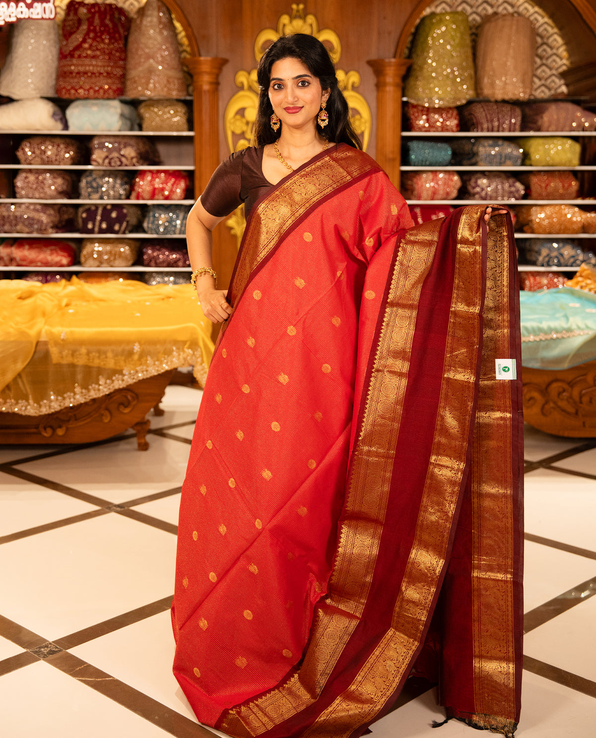 Red With Maroon Chettinad cotton saree featuring Gold zari strips with peacock motifs on body, complemented by contrast colour border with zari design & grand pallu, comes with matching blouse piece.