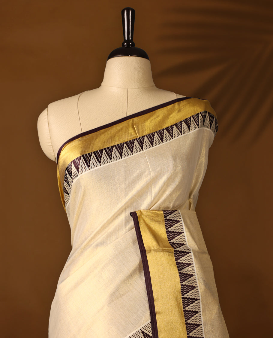 Elegant Light Gold colour Tissue Kerala saree featuring Plain body and traditional golden zari kasavu border with chocolate colour temple work offering a classic and graceful look, paired with a matching blouse.