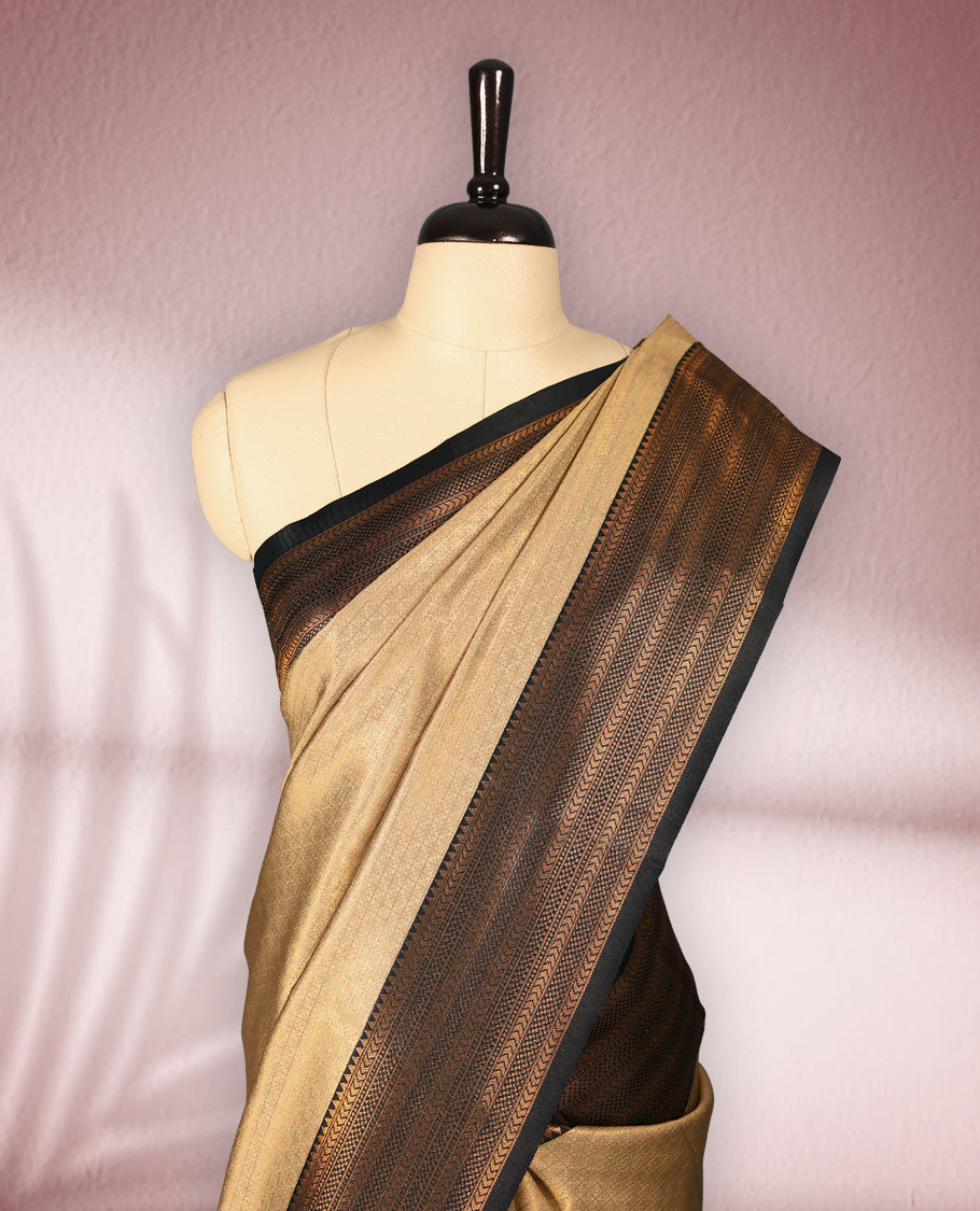 Beige colour semi silk brocade saree featuring intricate gold zari woven patterns across the body, paired with a rich Black and gold zari woven border in traditional motifs, with matching blouse