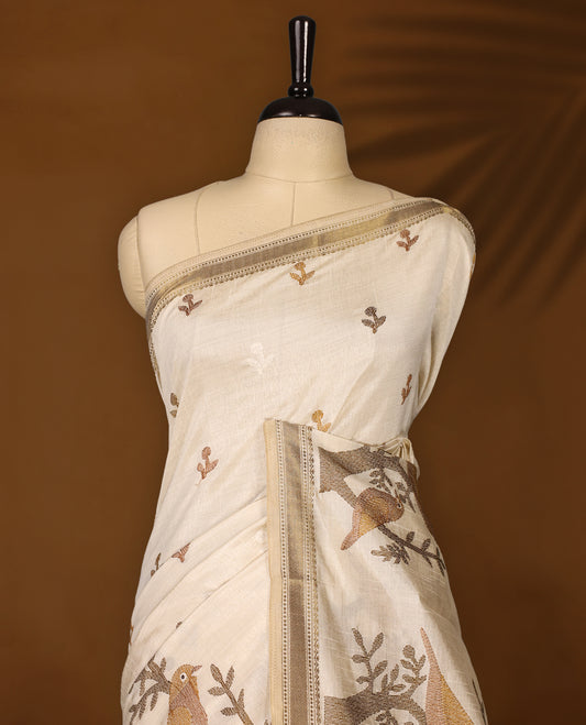 Soft Tussar saree in elegant off white shade, featuring intricate bird and branch motifs across the body, enhanced with a subtle grey golden woven border and pallu, paired with a matching blouse.
