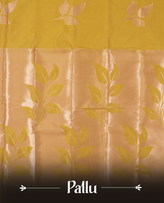 Mustard yellow colour semi silk saree adorned with elegant leaf motifs on the body, complemented by a shimmering golden zari woven pallu and border, and paired with a matching blouse