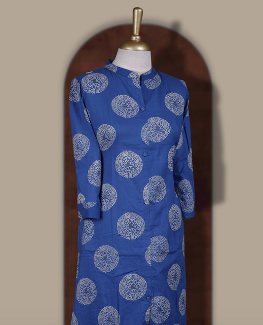 Brick blue colour cotton cord set featuring a straight kurta with a mandarin collar, front buttons, and three quarter sleeves & adorned with white circular block prints and paired with matching palazzo pants.