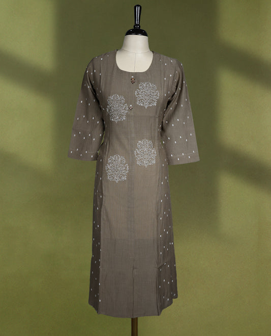 Chic brown colour kurti featuring a round neckline, three quarter sleeves, delicate white floral motifs on the front, and subtle polka dot accents on the sleeves and side panels
