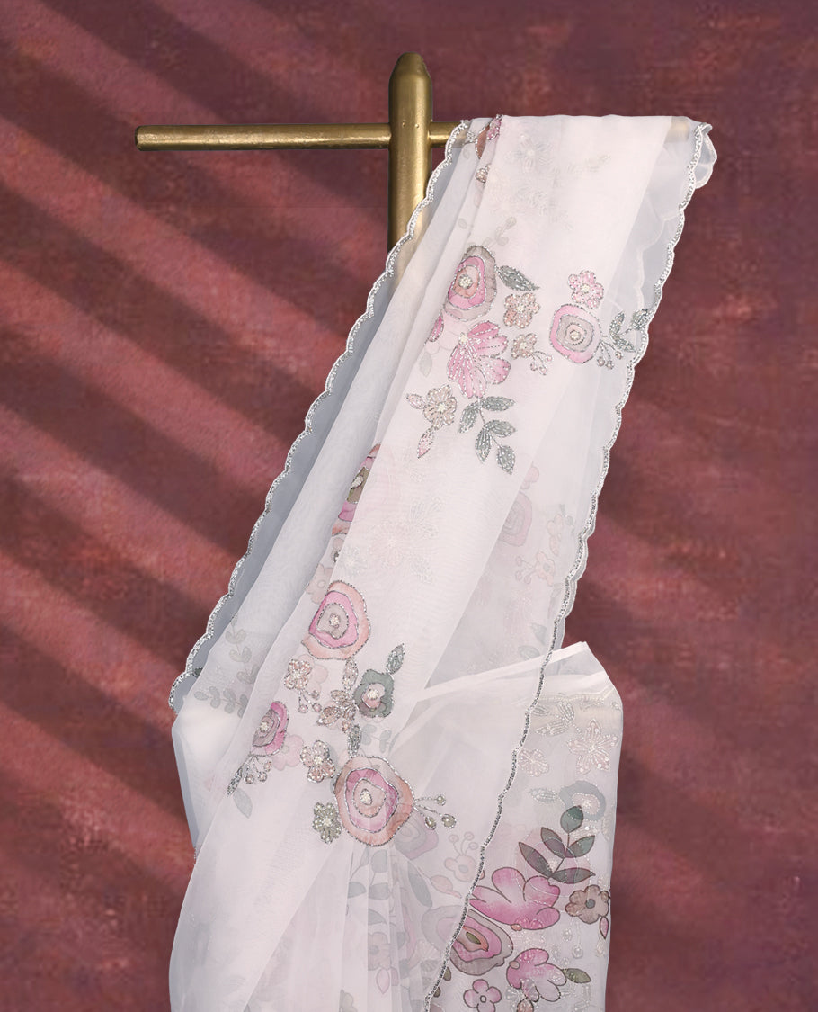 White colour pure organza saree featuring Multi Colour floral prints with intricate bead and sequin work across the body, adorned with a matching embellished border, complemented by a worked pallu and paired with a heavily worked matching blouse.