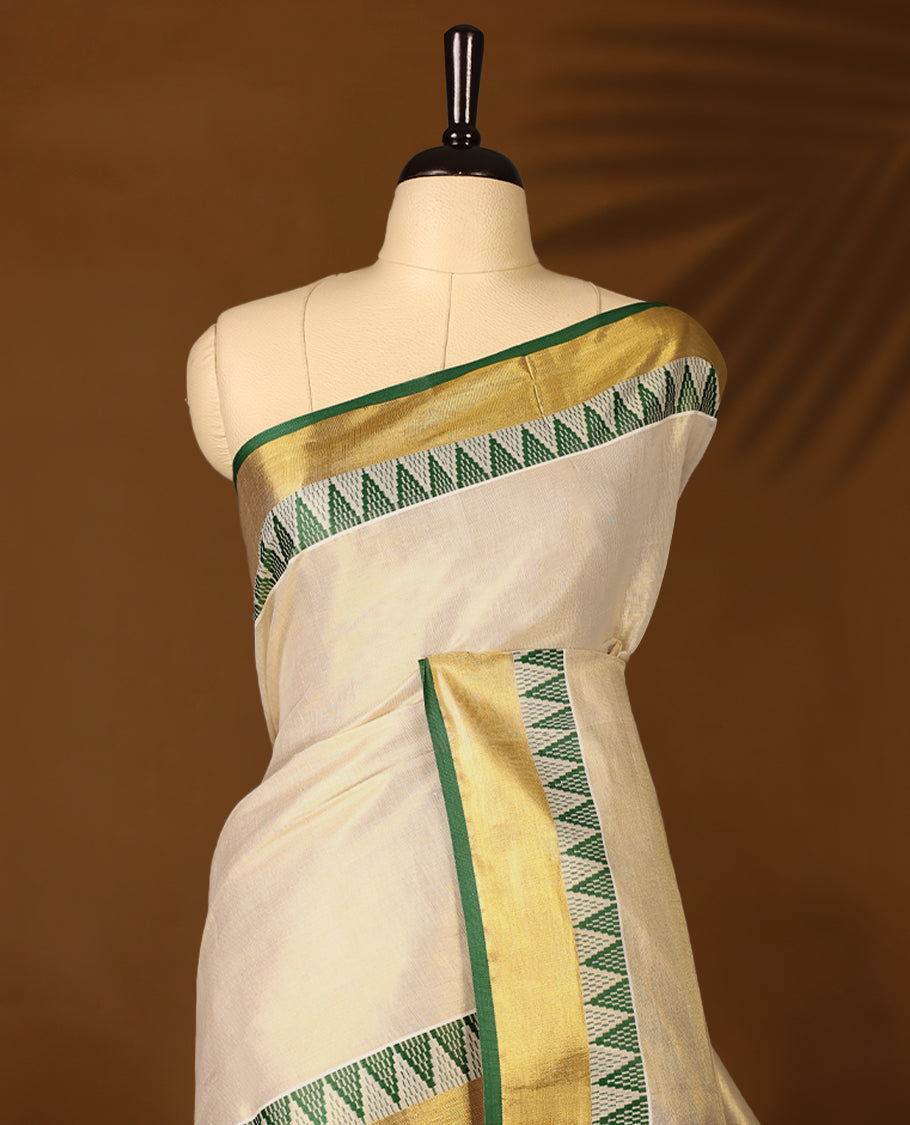 Elegant Light Gold colour Tissue Kerala saree featuring Plain body and traditional golden zari kasavu border with Green colour temple work offering a classic and graceful look, paired with a matching blouse.