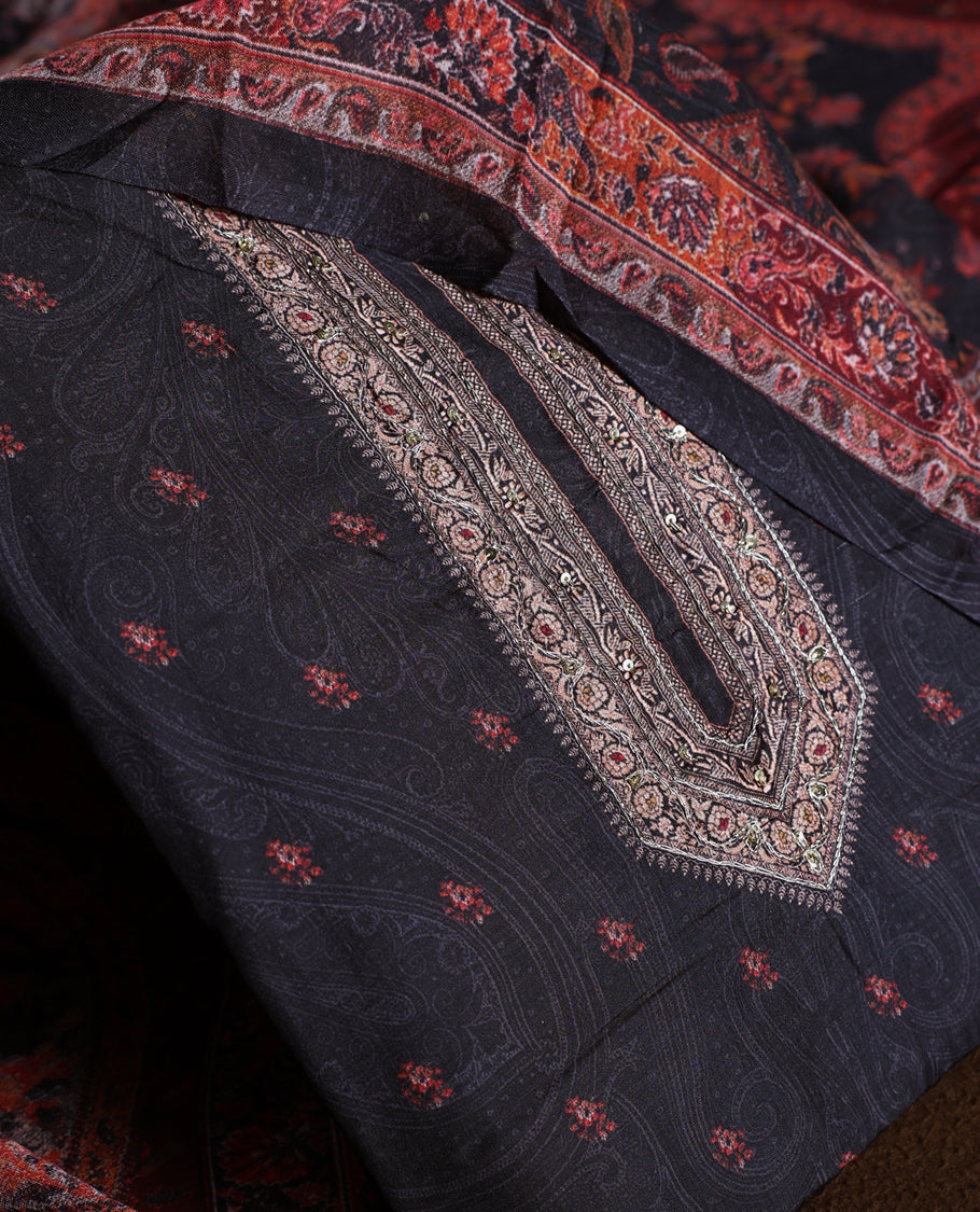 Black colour churidhar material with elegant maroon embroidery and delicate motifs, complemented by a plain matching bottom and dupatta.