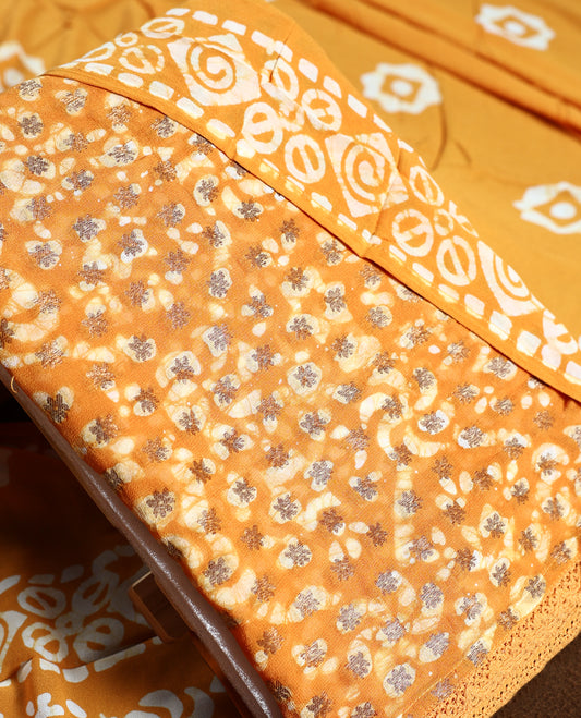 Deep yellow colour churidhar material featuring delicate floral patterns with gold highlights and bold block designs, paired with a plain matching bottom and vibrant dupatta.