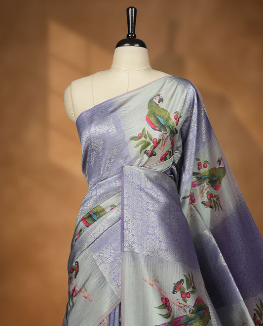 Gray Blue colour semi tussar Banarasi saree featuring printed parrot and floral motifs, gray blue zari border, and a matching blouse with woven accents.