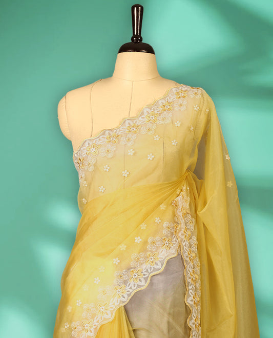 Yellow and White colour double shade organza saree with delicate floral embroidery on body, intricately embroidered scallop border, floral embroidered design on pallu, with matching blouse