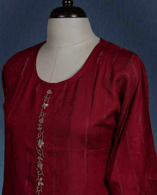 Maroon colour kurti with subtle vertical self stripes, adorned with delicate golden thread embroidery along the front placket, featuring a round neckline and stylish three quarter sleeves.