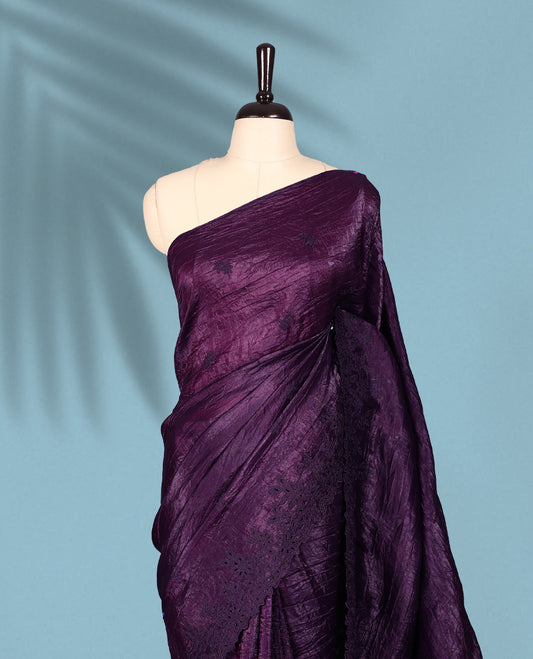 Deep Grape Colour crush soft silk saree boasts a lustrous crinkled texture with subtle self colored floral Motifs on the body and an elegant Floral thread cutwork border, paired with a matching blouse.