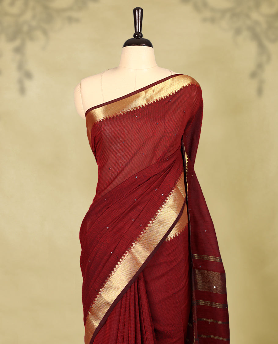 Maroon colour Chanderi cotton saree featuring a subtly textured body with delicate buti work, complemented by a rich golden zari border with matching blouse