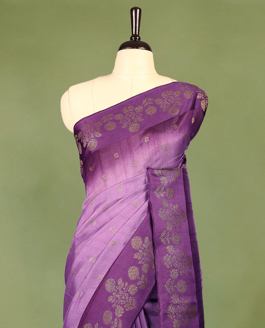 Lavender and purple double shade semi Banaras Tussar Georgette saree adorned with elegant antique gold zari floral motifs across the body, featuring a detailed woven border and grand pallu, paired with a matching blouse piece.