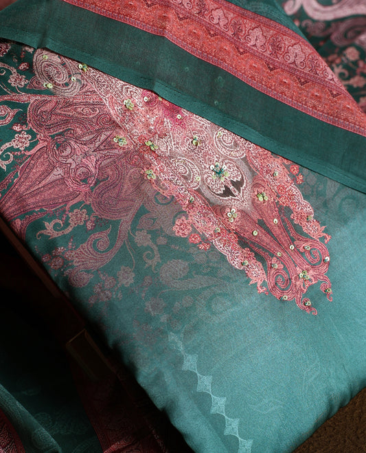 Dark green colour churidhar material featuring intricate embroidery with subtle paisley patterns, paired with a richly printed dupatta and plain bottom.