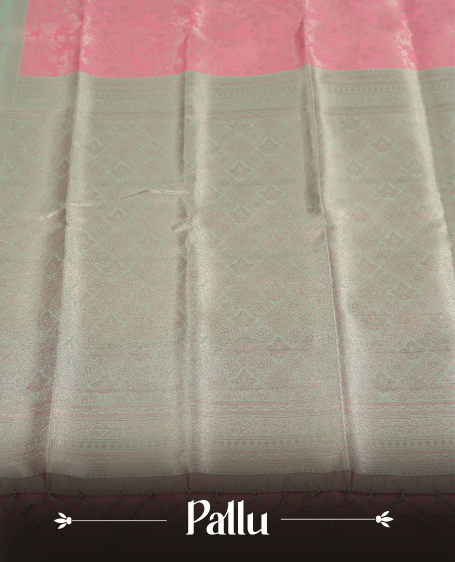 Pink colour semi silk saree adorned with subtle silver floral patterns on the body, complemented by contrasted a silver pallu intricately woven with rich floral patterns border and pallu, and paired with a matching blouse