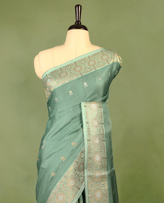 Pastel Green colour pure Banaras crepe saree showcases elegant silver zari Flower Motifs all over the body, a traditional Banarasi gold zari border, a rich intricately woven pallu, and comes with a matching blouse.