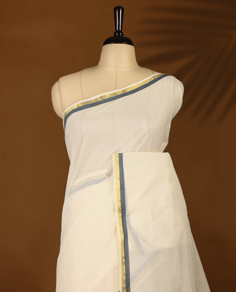 Elegant off white colour cotton Kerala saree featuring a plain body and traditional golden zari border with a hint of Midnight Blue, offering a classic and graceful look, paired with a matching blouse.