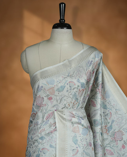 Mint green colour semi tussar silk saree featuring all over floral and leaf motifs on the body with a subtle self border and tasselled pallu, paired with a matching blouse.