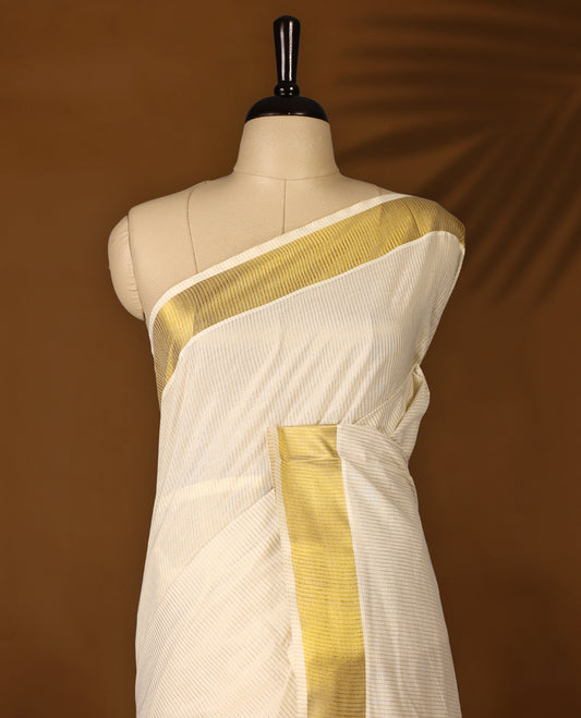 Elegant off white colour cotton Kerala saree featuring gold Zari Striped body, gold zari traditional kasavu border offering a classic and graceful look, paired with a matching blouse.