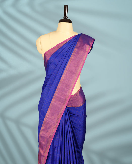 Royal blue Colour body with elegant checks, paired with a vibrant magenta pink zari border, comes with a matching blouse.