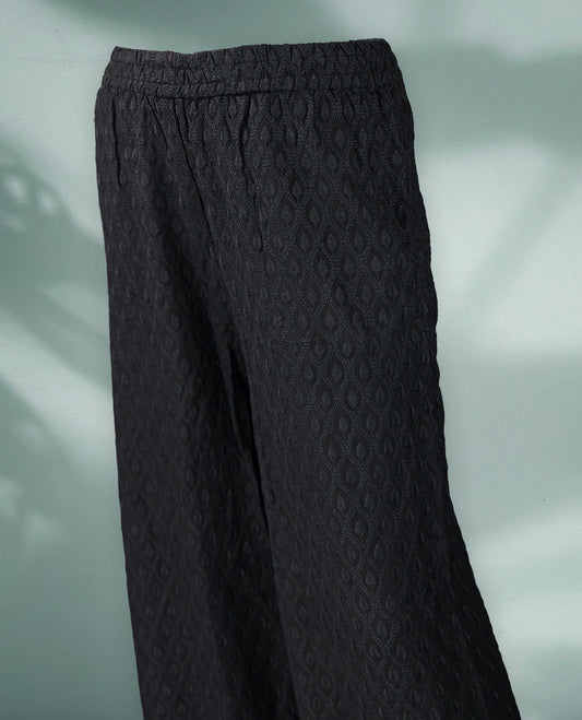 Black colour textured palazzo pants with intricate all over embroidery and a wide leg silhouette
