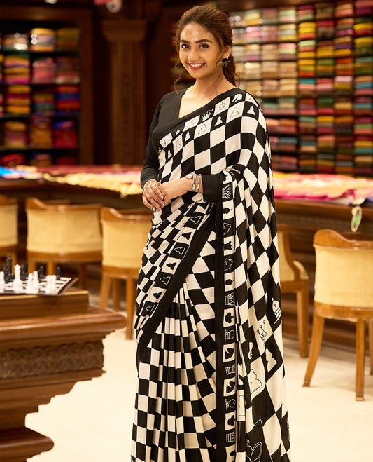 Striking black and white chessboard themed saree with bold checkered patterns and unique chess piece motifs across the body and pallu, paired with a solid black matching blouse for a bold, statement look