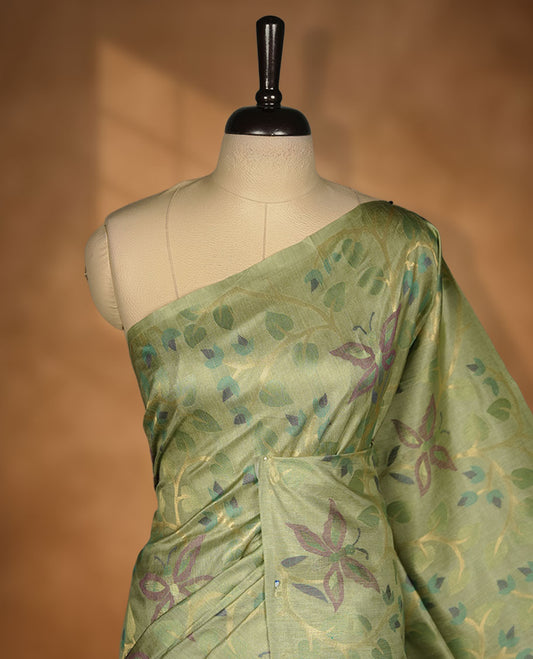 Light green colour semi jamdani tussar silk saree featuring woven Floral kodi & butterfly motifs on the body, complemented by a self colour without border pallu, paired with a matching blouse.