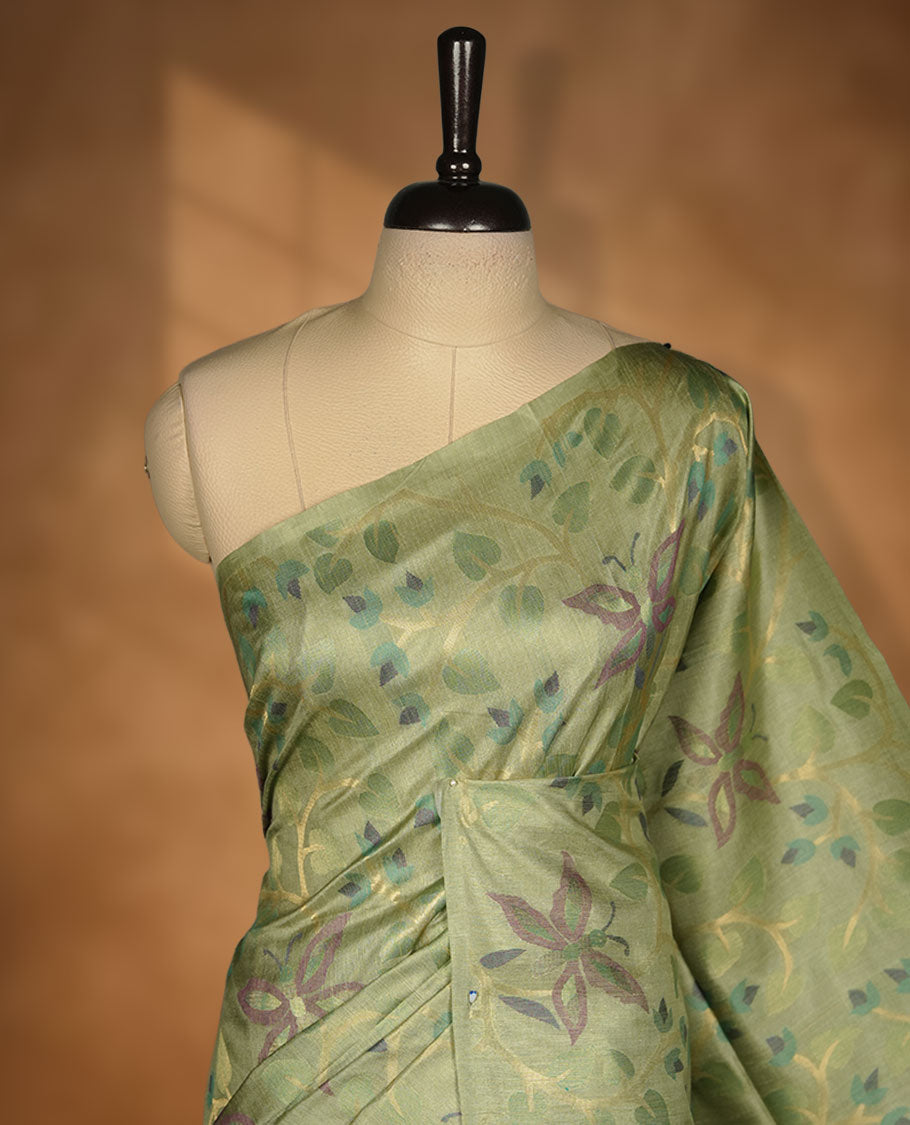 Light green colour semi jamdani tussar silk saree featuring woven Floral kodi & butterfly motifs on the body, complemented by a self colour without border pallu, paired with a matching blouse.