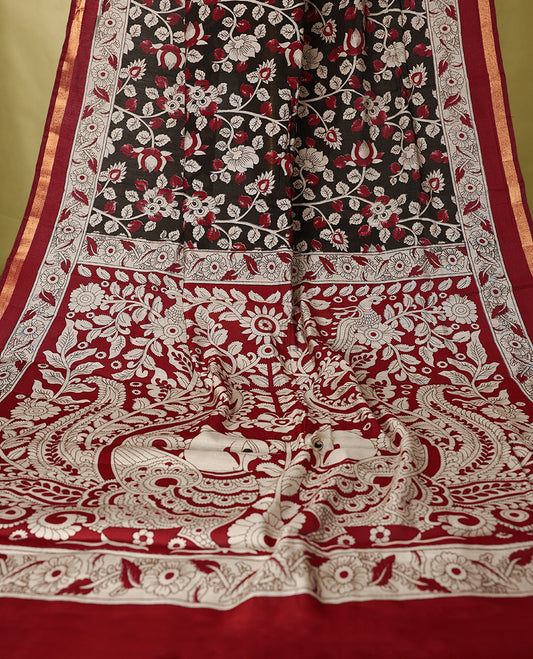 Black colour chanderi cotton saree with floral printed body, maroon border with traditional floral motifs, intricately designed pallu with peacock and floral patterns, with matching blouse