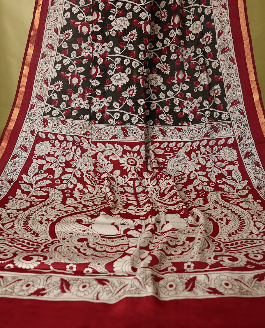 Black colour chanderi cotton saree with floral printed body, maroon border with traditional floral motifs, intricately designed pallu with peacock and floral patterns, with matching blouse