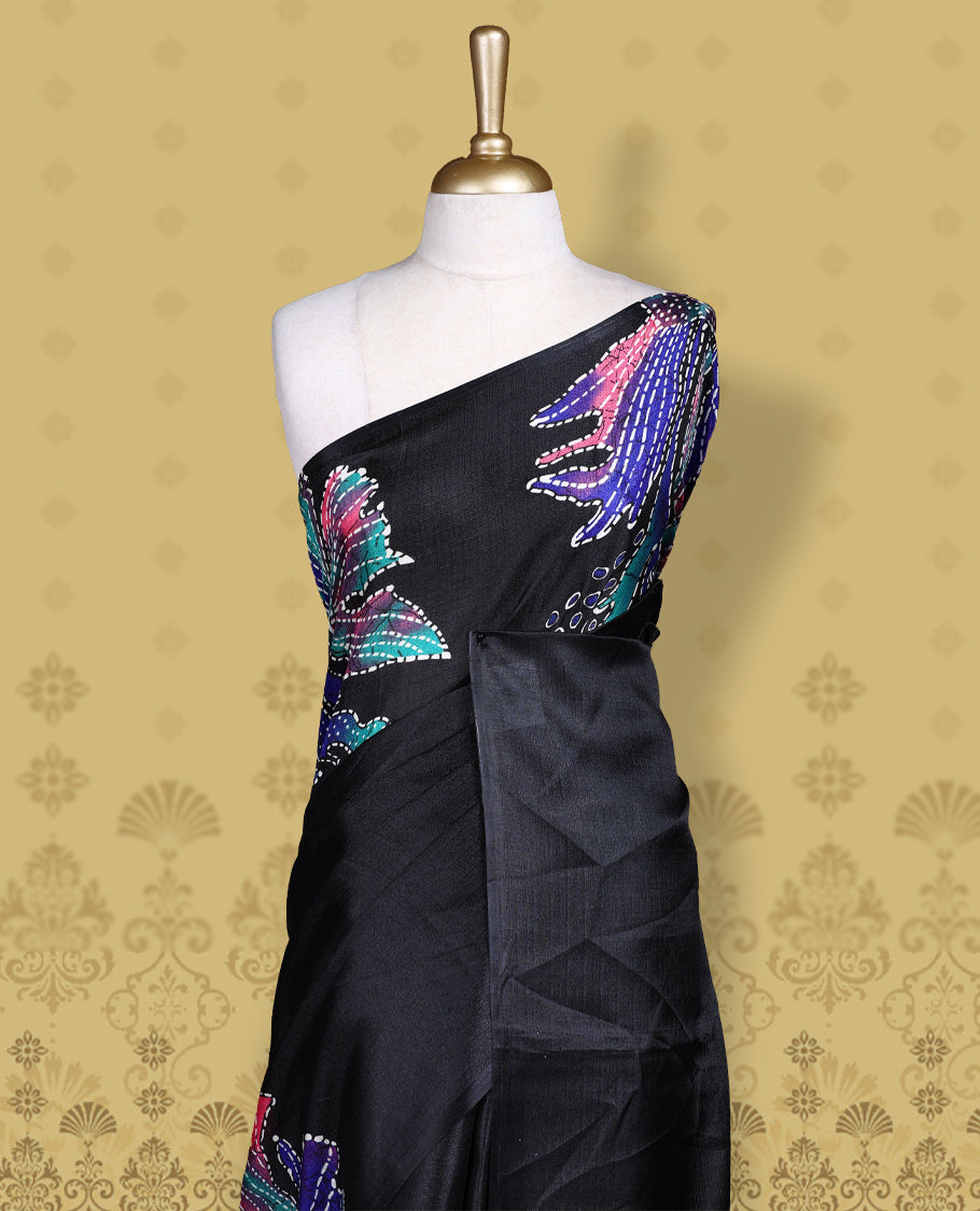 Black colour semi khadi silk saree adorned with navy blue,pink and aqua green colour bold floral motifs across the body, designed without a border for a contemporary touch, and paired with a matching blouse.