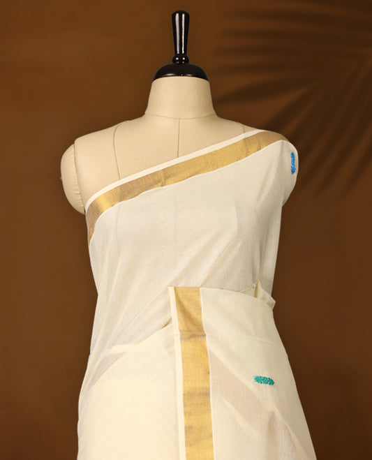 Elegant Off white colour cotton Kerala saree featuring colorful thread buttas and vibrant temple motifs on the pallu, finished with a classic golden zari border and paired with matching blouse.