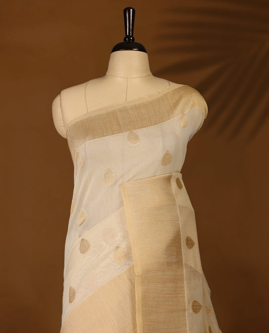 Light gold colour Organza Kerala saree featuring Gold zari Motifs on the body, Gold Kasavu border, Comes paired with a coordinated matching blouse.