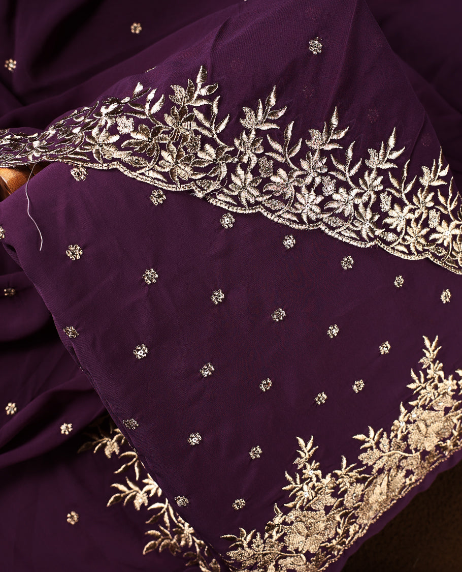 Deep purple churidhar material featuring elegant gold floral embroidery and delicate motifs, paired with a matching embroidered dupatta and plain bottom.