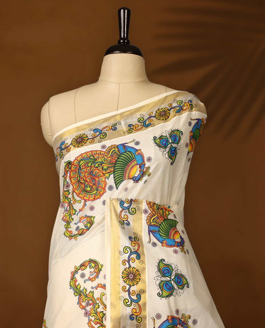 Off white colour Kerala cotton saree featuring vibrant peacock & floral prints, enhanced with a traditional golden kasavu border and A festive ready drape paired with a matching blouse, perfect for graceful celebrations.