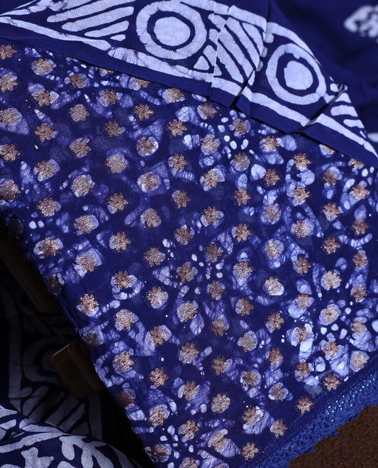 Navy blue colour churidhar material adorned with gold and copper toned floral patterns and bold block designs, paired with a plain matching bottom and stylish dupatta, perfect for festive evenings and traditional gatherings.