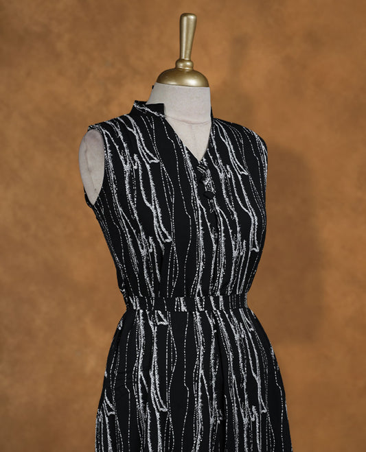 Black sleeveless knee-length shirt dress with abstract white wavy print, band collar, front button placket, and elasticated waistline