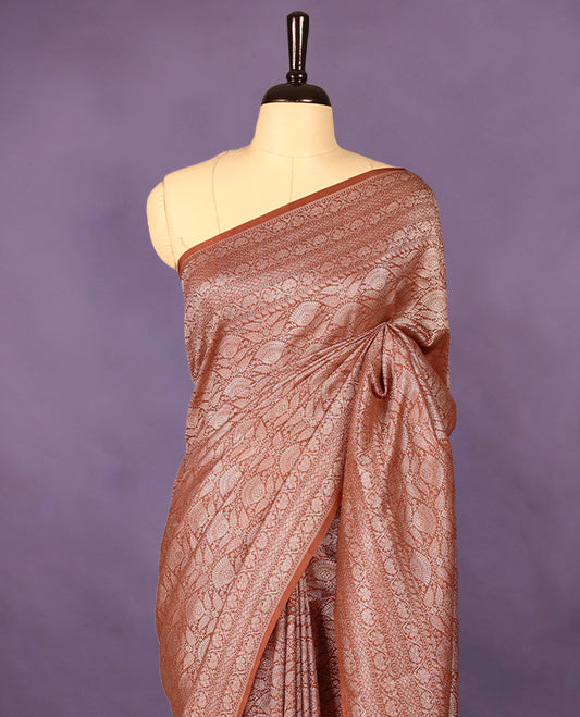 Light brown colour semi Banaras Katan saree featuring an antique silver zari jacquard body, complemented by a self colour traditional border with a floral kodi design, paired with a matching blouse
