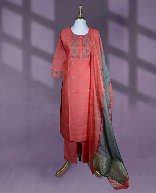 Vibrant rust orange colour salwar set featuring a round neckline, three quarter sleeves, delicate thread embroidery on the yoke and sleeves, with a contrasting dupatta and matching bottom