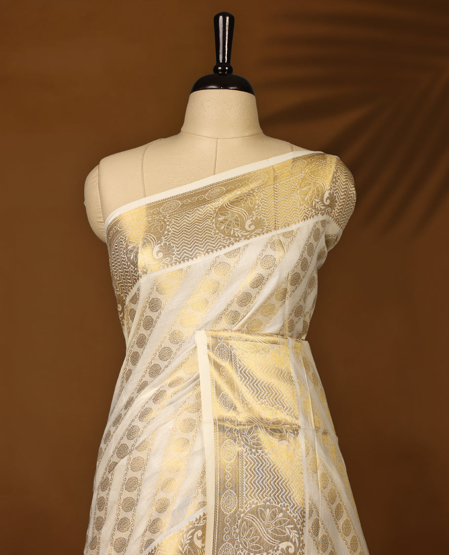 Elegant off white colour soft cotton Kerala saree featuring golden paisley and floral motifs in diagonal stripes, enhanced by a rich golden pallu with tassels, paired with a matching blouse, perfect for traditional and festive occasions.