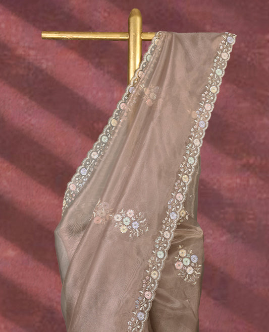 Pastel taupe colour pure organza saree featuring all over floral sequin work, adorned with a matching intricately worked floral border, complemented by a richly embellished pallu and paired with a heavily worked matching blouse.