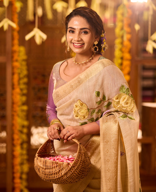 Beige colour Kerala saree crafted in soft fabric, adorned with elegant yellow and purple floral embroidery across the body and pallu, highlighted with a subtle woven zari border, paired with a matching blouse