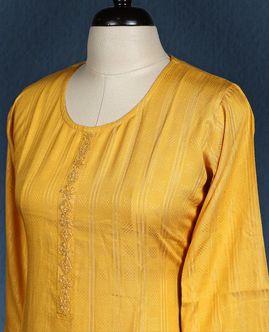 Mustard yellow colour kurti with subtle vertical self stripes, adorned with delicate thread embroidery along the front placket, featuring a round neckline and stylish three quarter sleeve